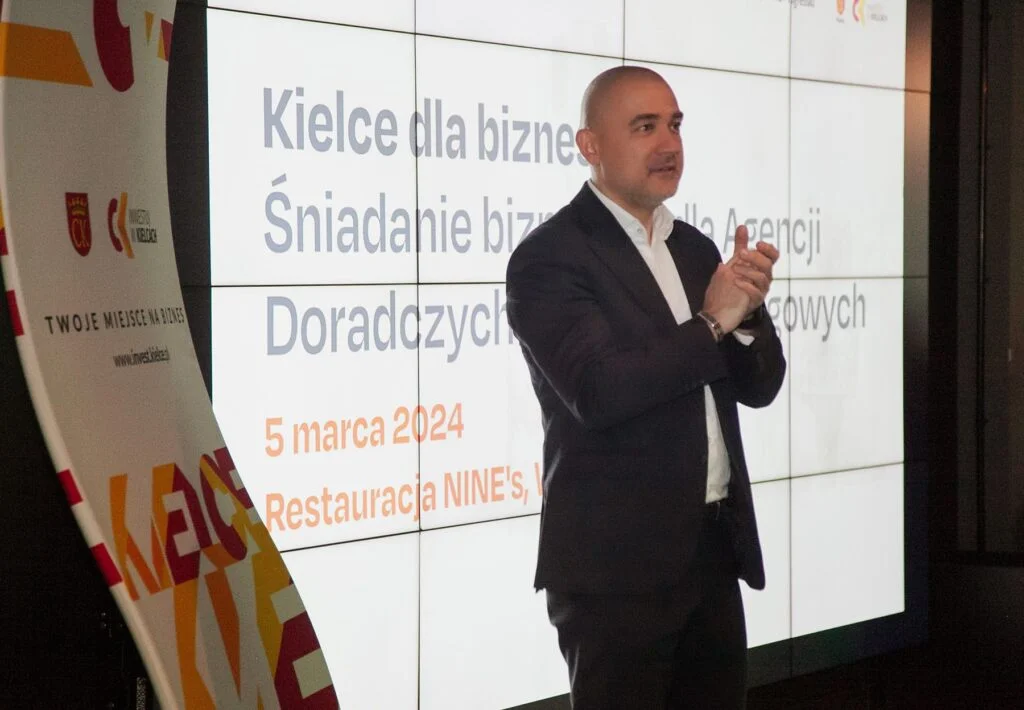 Wiktor Doktór stojący na scenie z gestem oklasku