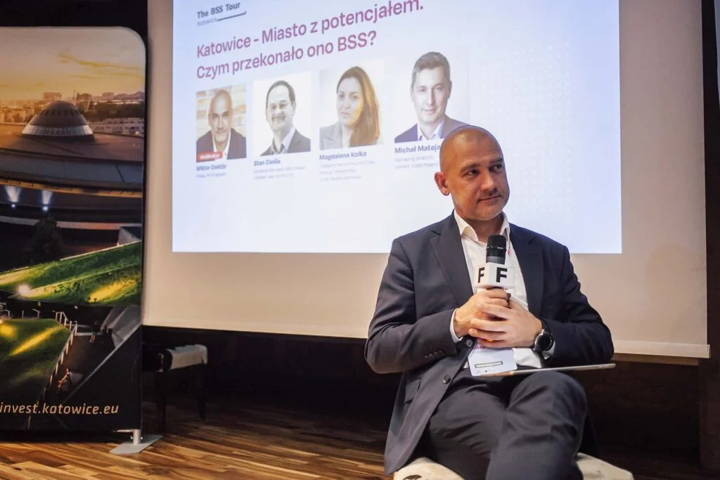 Wiktor Doktór siedzący na scenie, słuchając zadawanego pytania