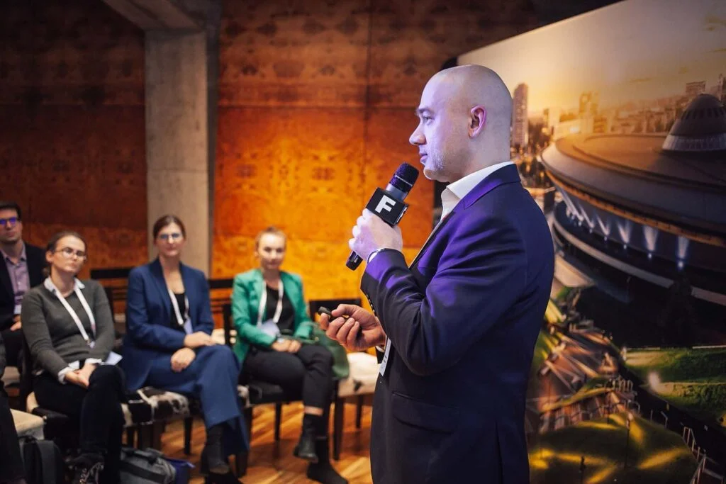 Wiktor Doktór stojący na scenie, występujący przed patrzącą na niego publicznością